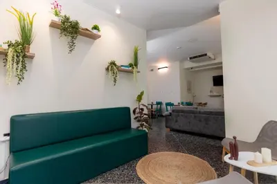 a living room with a green couch and plants on the wall at Nobia 1 in Athens