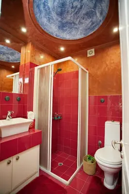 a red bathroom with a toilet and a sink at Blue Oliva House in Aghia Marina