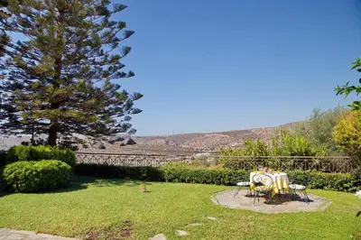 a garden with a table and chairs and a tree at Blue Oliva House in Aghia Marina