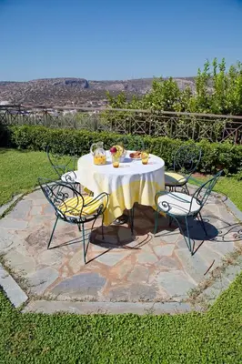 a table with a yellow table cloth and four chairs at Blue Oliva House in Aghia Marina