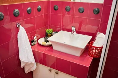 a red tiled bathroom with a white sink at Blue Oliva House in Aghia Marina