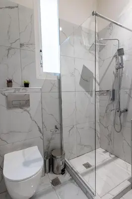 a white bathroom with a shower and a toilet at Nobia 2 in Athens