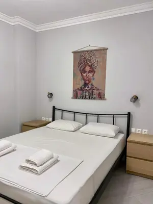 a bedroom with a bed with a painting on the wall at City Core Studio in Athens