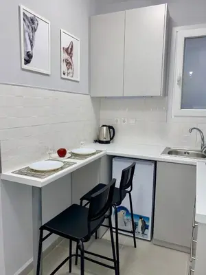 a white kitchen with two chairs and a counter at City Core Studio in Athens