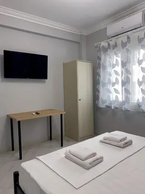a bedroom with a bed and a desk and a television at City Core Studio in Athens