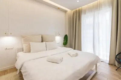 a bedroom with a large white bed with two towels on it at Unique Apartment Ideal for Couples in Piraeus