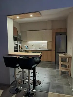 a kitchen with a counter and some bar stools at Colmena Arty Athens Apartment in Athens