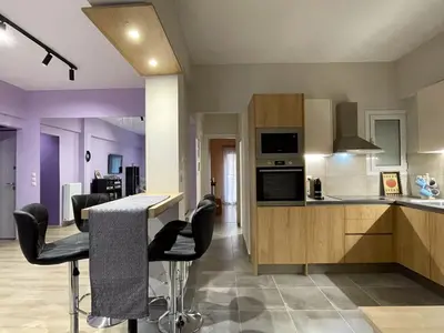 a kitchen with a counter and chairs in a room at Colmena Arty Athens Apartment in Athens