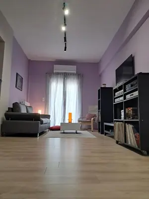 a living room with purple walls and a couch at Colmena Arty Athens Apartment in Athens