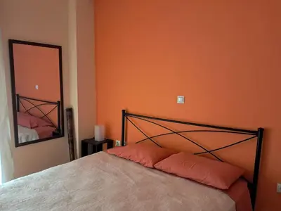 a bedroom with a bed with an orange wall at Colmena Arty Athens Apartment in Athens