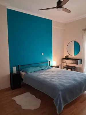 a blue bedroom with a bed with a blue wall at Colmena Arty Athens Apartment in Athens