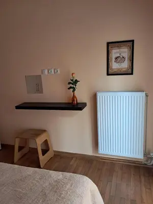 a bedroom with a bed and a radiator and a stool at Colmena Arty Athens Apartment in Athens