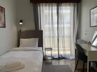 a bedroom with a bed and a desk and a window at aθens flat in Athens