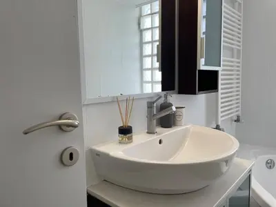 a white sink in a bathroom with a window at aθens flat in Athens
