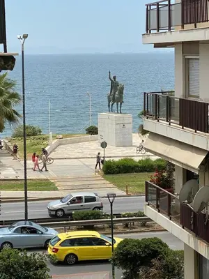 a statue of a man on a horse next to the ocean at MediTerra Stay Athens Riviera Seaview in Athens
