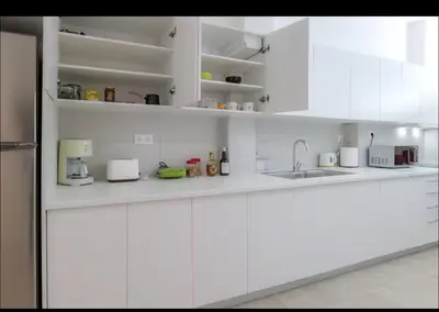 a white kitchen with white cabinets and appliances at Όνειρα γλυκα in Athens
