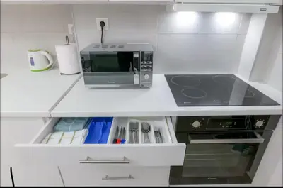 a white kitchen with a microwave and a stove at Όνειρα γλυκα in Athens