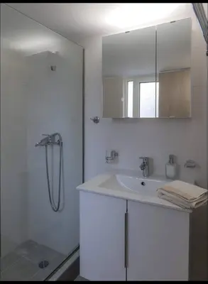 a white bathroom with a shower and a sink at Όνειρα γλυκα in Athens