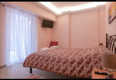 a bedroom with a bed and a large window at Όνειρα γλυκα in Athens