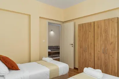 a bedroom with two beds and a closet at Ofi Continental - 3BR, Koukaki in Athens