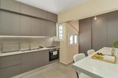 a kitchen with a sink and a table with chairs at Ofi Continental - 3BR, Koukaki in Athens