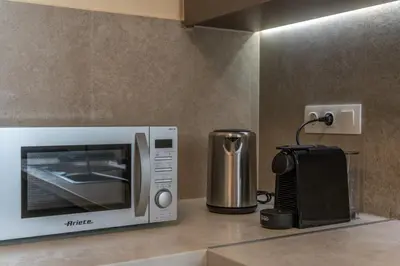 a microwave oven sitting on top of a kitchen counter at Ofi Continental - 3BR, Koukaki in Athens