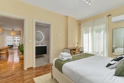 a bedroom with a large bed and a living room at Ofi Continental - 3BR, Koukaki in Athens