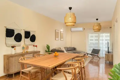 a living room with a wooden table and chairs at Ofi Continental - 3BR, Koukaki in Athens