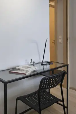 a glass desk with a chair and a laptop on it at Elegant Design Stay in Koukaki in Athens