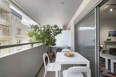a small balcony with a white table and chairs at Elegant Design Stay in Koukaki in Athens