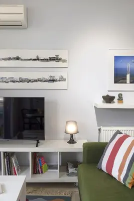 a living room with a green couch and a tv at Elegant Design Stay in Koukaki in Athens