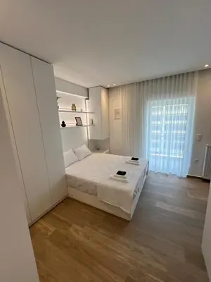 a bedroom with a bed and a large window at Μοντέρνο στούντιο στην Καλλιθέα in Athens