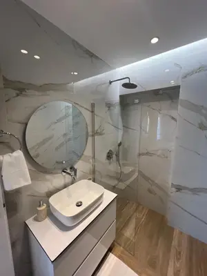 a white bathroom with a sink and a shower at Μοντέρνο στούντιο στην Καλλιθέα in Athens