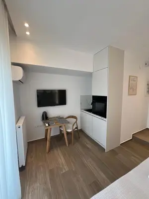 a living room with a table and a tv at Μοντέρνο στούντιο στην Καλλιθέα in Athens
