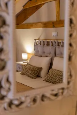 a reflection of a bed with pillows in a mirror at Strofilia House Near ATH Airport in Markopoulo