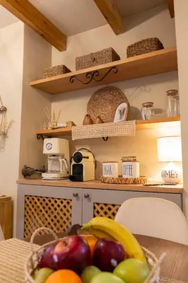 a kitchen with a bowl of fruit on a table at Strofilia House Near ATH Airport in Markopoulo