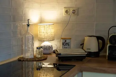 a kitchen counter with a bottle and a lamp on it at Strofilia House Near ATH Airport in Markopoulo