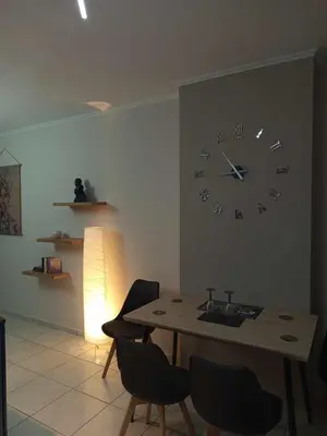 a dining room with a clock on the wall at Chrysa's house in Piraeus