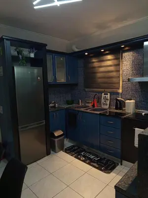 a kitchen with blue cabinets and a stainless steel refrigerator at Chrysa's house in Piraeus