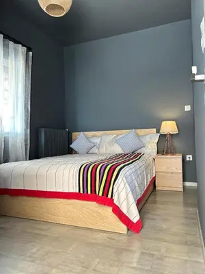 a bedroom with a bed with a blue wall at Ben's Penthouse Athens in Athens