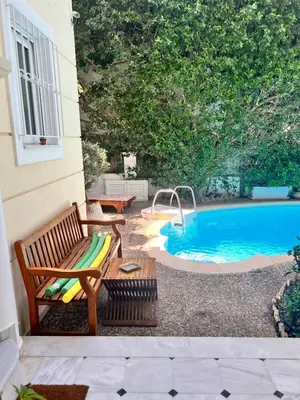 a patio with a bench and a swimming pool at Stunning villa with private pool in Alimos Athens in Athens