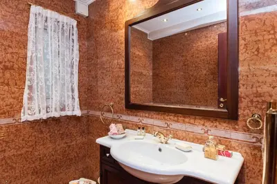 a bathroom with a sink and a mirror at Stunning villa with private pool in Alimos Athens in Athens