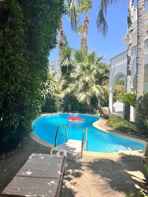 a swimming pool with a picnic table in front of a house at Stunning villa with private pool in Alimos Athens in Athens