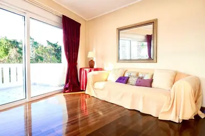 a living room with a white couch and a mirror at Stunning villa with private pool in Alimos Athens in Athens