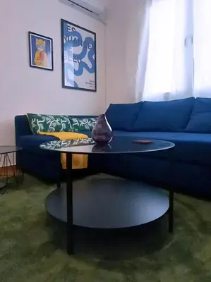 a living room with a blue couch and a table at Urban Pop Athens - City & Culture in Athens