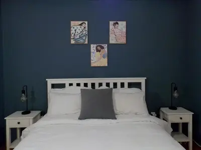 a bedroom with a white bed with three pictures on the wall at Urban Pop Athens - City & Culture in Athens