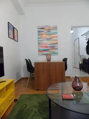 a living room with a table and a tv at Urban Pop Athens - City & Culture in Athens