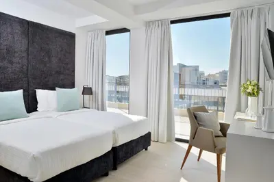 a bedroom with a large bed and a large window at The Apartment by Athenaeum Hotels in Athens