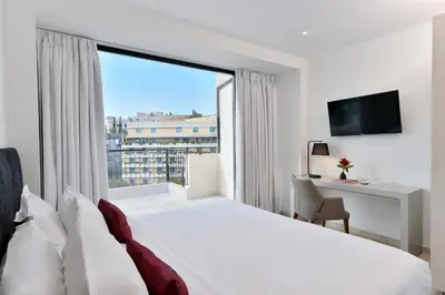 a hotel room with a bed and a large window at The Apartment by Athenaeum Hotels in Athens
