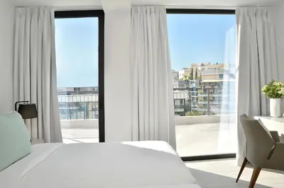 a bedroom with a white bed and a large window at The Apartment by Athenaeum Hotels in Athens